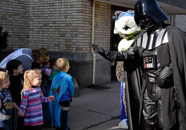 Youngsters from the Children's Learning Center warily approach Darth Vader's offer of a "high five."