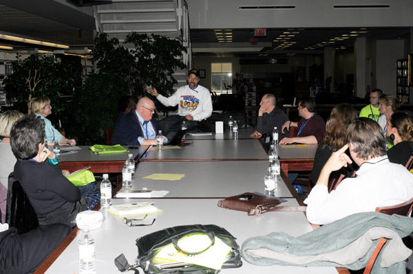 With their scheduled speaker's flight delayed, other presenters hold a makeshift roundtable on the library's first floor.
