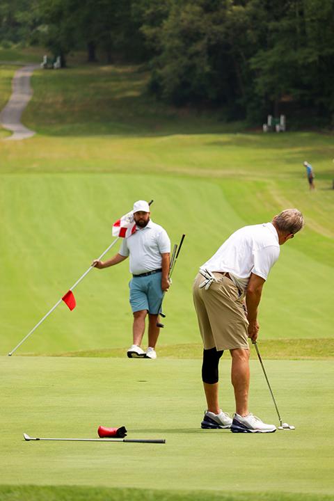 A TurnKey Electric Inc. golfer lines up a putt.