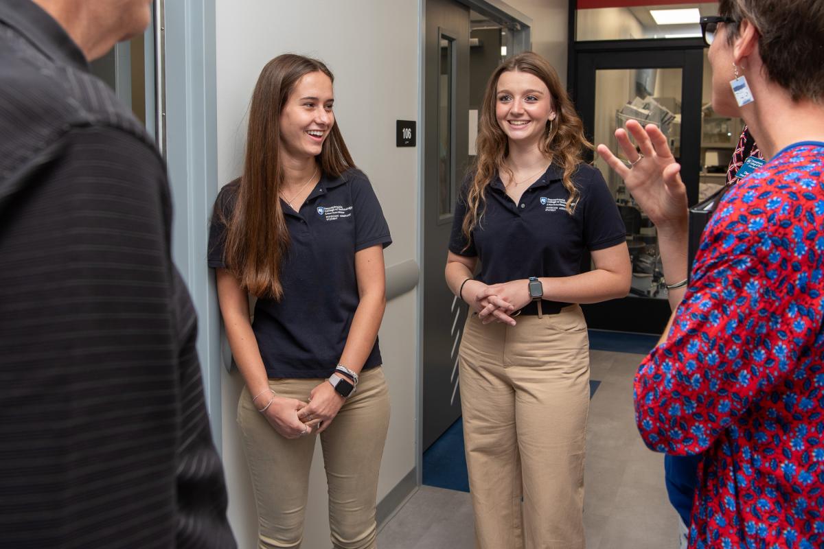 Outside the Anatomy Lab, Gabrielle R. Henry, of McClure, and Meghan M. DeLay, of Fleetwood, converse with open house visitors. 