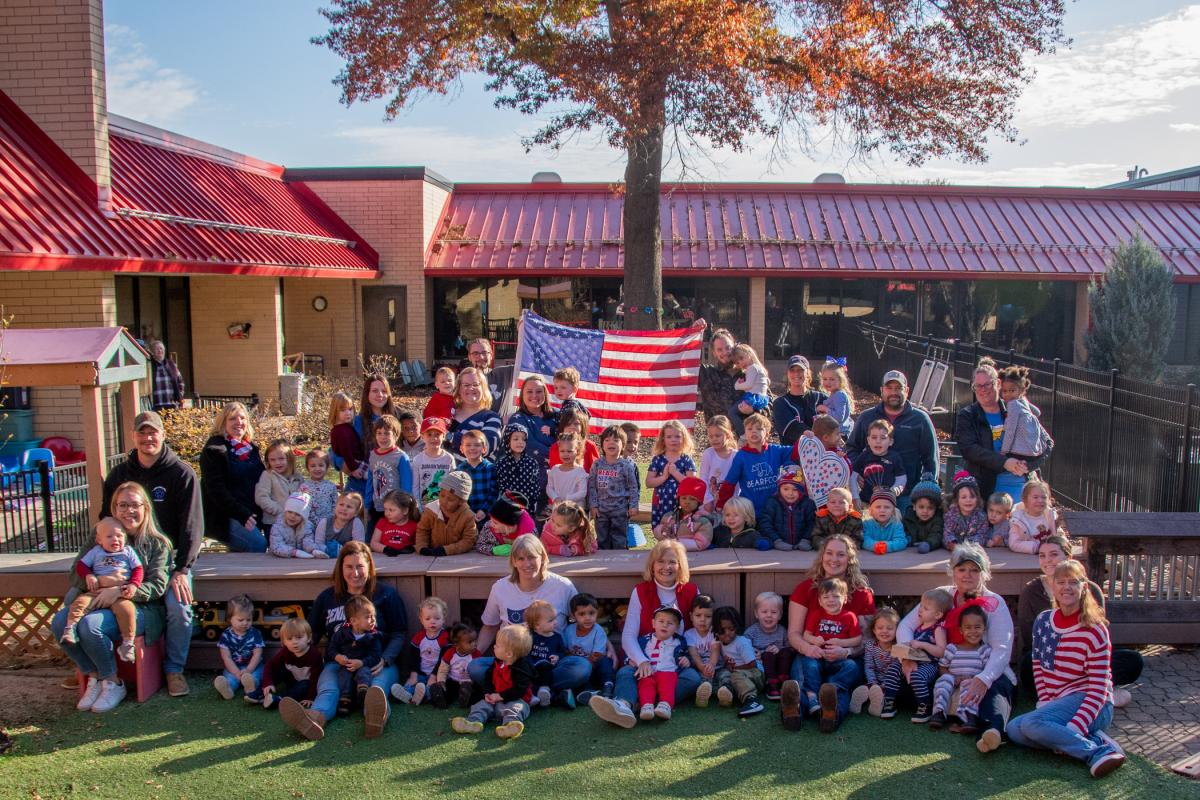 The Dunham Children's Learning Center eagerly embraced the celebration, holding a "Red, White & Blue Day" on Nov. 3. Honoring veterans among its families, as well as students who are currently serving, the CLC invited those parents to join a group photo in the play area. (Photo by Jennifer A. Cline, writer/magazine editor).