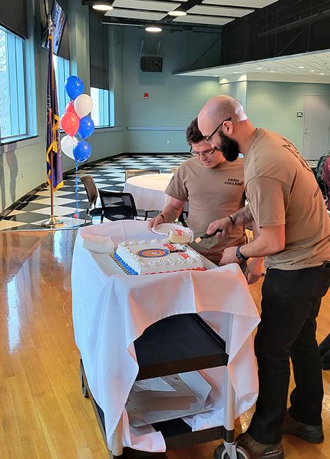 Cutting the cake are Mike A. Cruz (foreground), a heating, ventilation & air conditioning engineering technology student from Mechanicsburg; and Alex N. Hernandez, of Pittsburgh, enrolled in construction management.