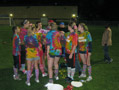 Colorfully tie-dyed, upper-class women huddle with their coaches