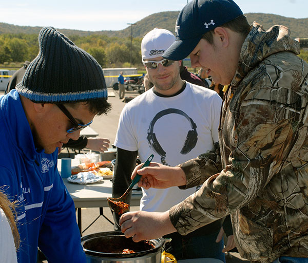 Craig C. Baker, right, serves up a winner in the Chili Cook-Off. The secret to his first-place finish? Italian sausage, corn and 