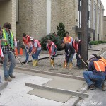 Spreading the concrete, from left, are Fishbein, MacMorris, Boylan, Simpson, Reber and Velez. Workman is standing at the rear; Gustafson is against the pole. Chad B. Gordner is leaning down at screed and Gray is closest to the chute.