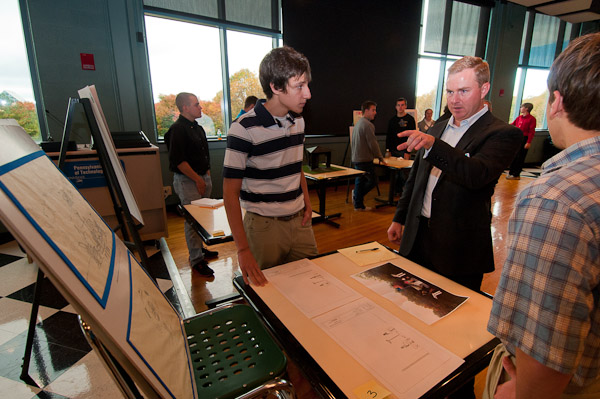 Michael A. Gibble, ’00, architectural technology (center), shares his insights with architectural technology students Anthony J. Reed (left), of Flinton, and Levi Speicher (back to camera), of Manns Choice, during a design review session in Penn’s Inn. 