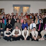 Students mingle with waitstaff and mentors for an after-dinner group photo.