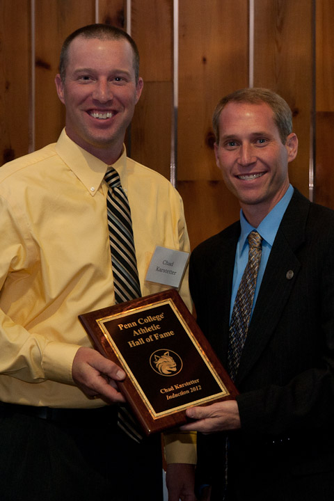 Chad L. Karstetter (left) accepts his Hall of Fame plaque from Scott E. Kennell, director of athletics.