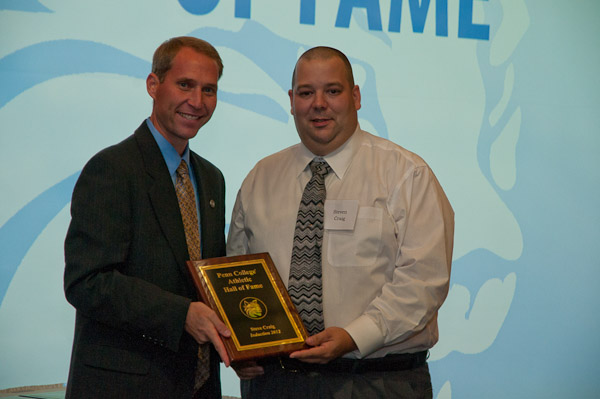 Steven Craig (right) accepts his Hall of Fame plaque from athletic director Scott E. Kennell.