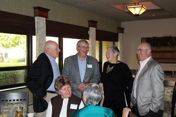 Alumni brothers Darryl ('72, liberal arts), and Allan Kehrer, '74, business management, talk with President Gilmour and her alumnus husband, Fred, during a Sunday brunch for award-winning graduates.