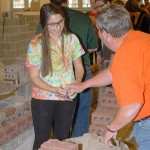 A Penn State student pleasantly accepts a trowel (and some learned advice) from the industry's Ron Bower.