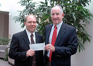 Robb Dietrich, executive director of the Pennsylvania College of Technology Foundation, left, accepts a $10,000 donation from John Hambrose, of Waste Management Inc.