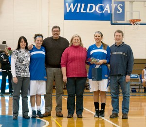 Lady Wildcats Kierstin Steer (second from left) and Mackenzie Brown join their parents at midcourt for Senior Day recognition.