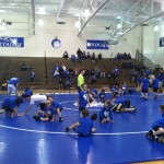 Elementary wrestlers get some tips from Logan A. Gresock, a construction management major and award-winning Wildcat student-athlete.