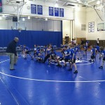 Assistant wrestling coach Richard E. Shnyder puts youngsters through a workout during an informal clinic.
