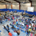Students in the morning session attend the awards ceremony, watching the winning videos and cheering their classmates.