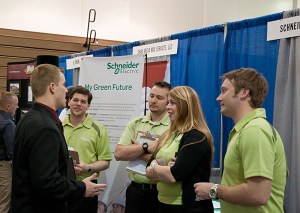 A Career Fair attendee gains the collective ear of the full team from Schneider Electric.