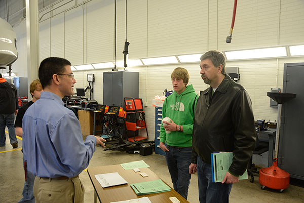 Joseph A. Taviani, a member of the Honda PACT faculty, talks with a family in the Parkes Automotive Technology Center.