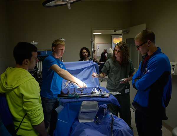 Shedding some light on surgical technology, with the help of 2012 alumna Jaime L. Binkley (background)