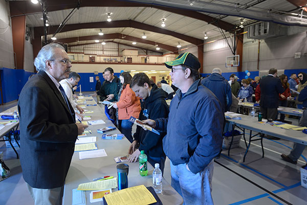 Helping a father and son plan an informative and enjoyable itinerary at check-in is Tom F. Gregory, associate vice president for instruction