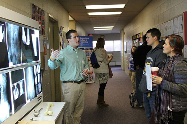 A student prospect and his mother speak with John H. Hunter, a 2010 radiography graduate.