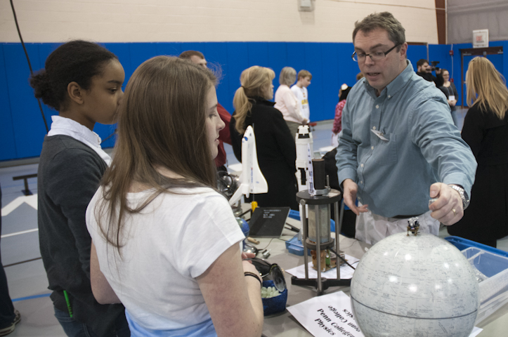 Penn College physics professor David S. Richards uses visual aids to talk about past U.S. space missions.