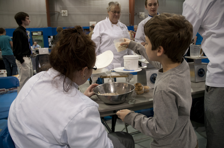 Baking and pastry arts student Megan R. Chapman helps a festival-goer to measure ingredients by weight. 