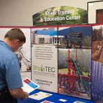 A participant visits the Shale Training & Education Center display in an outer hallway.