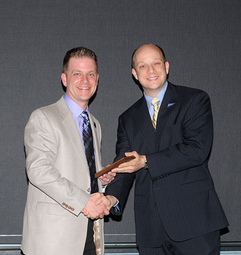 Chosen as Adviser of the Year was Phi Mu Delta’s Jason K. Eichensehr (left), joined on stage by Michael J. Hersh, assistant director of student activities for programming and operations.