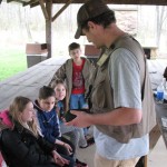 From a fitting vantage in a pondside pavilion, schoolchildren get a fishing lesson from Dustin S. Beane, of Kane, who was joined off-camera by Jenna H. Weston, of Altoona.