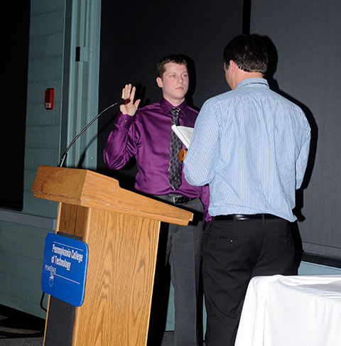 The SGA gavel is passed: Michael L. Spear, 2013-14 president, takes the oath of office from predecessor Ryan M. Enders.
