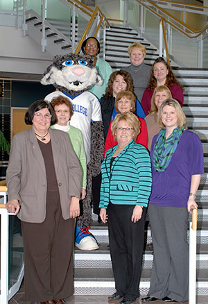 Penn College employees and the college mascot gather to celebrate progress toward endowment of a scholarship memorializing a co-worker. Front row, from left: Dianne S. Keister, financial aid specialist/needs analysis; Kate M. Wetzel, admissions office secretary; and Jessica S. Hunter, coordinator of educational loan programs. Second row: Candy S. Baran, director of financial aid; Joann Kay, coordinator of veterans affairs/work-study; and Nancy C. Petrosky, financial aid assistant. Third row: the Penn College Wildcat, Kimberly A. Venti, financial aid support services specialist; and Lori E. Baier, financial aid assistant. Back row, from left: Betty J. Lentz, financial aid assistant, and Kara L. Daneker, financial aid specialist/federal programs.