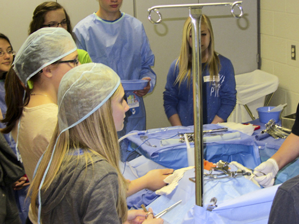 Students practice the role of a surgical technologist in the college’s operating-room setup.