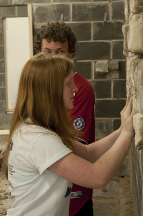 Students adhere cultured stone to a brick wall in the Construction Masonry Building.