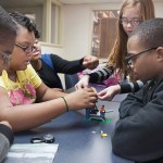 During a business workshop, middle schoolers collaborate to test a hypothesis about the most effective size for a workgroup. 