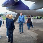 Aviation instructor Michael R. Robison leads a tour group outside the hangar.