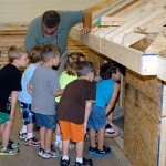 Visitors check out the structural integrity of students' construction work – including an assessment of whether the roof is sturdy enough "to hold Santa Claus."
