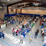 A patchwork of campus groups and civic organizations fills the floor of the Field House, where the event was moved under the perceived threat of rain.
