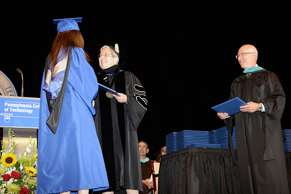Graduates cross the stage to receive administrative acknowledgement of their noteworthy accomplishment.