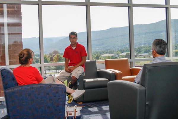 Rommel A. Cressman, a summer conference assistant, visits with parents in a Dauphin Hall lounge area. Cressman, a sophomore in electronics and computer engineering technology, hails from Lansdale. 