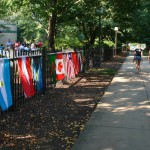 International flags decorate the Victorian House fence, welcoming visitors. 