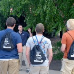 Admissions representative Caleb J. Swartz leads a tour group (toting commemorative backpacks) during Sunday's opening of Pennsylvania Free Enterprise Week.