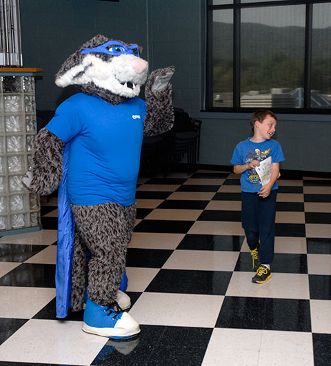 The Penn College Wildcat gives an impromptu dance lesson to a young attendee.
