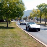 A caravan of vintage vehicles moves along Hagan Way, en route to the Parkes Automotive Technology Center.
