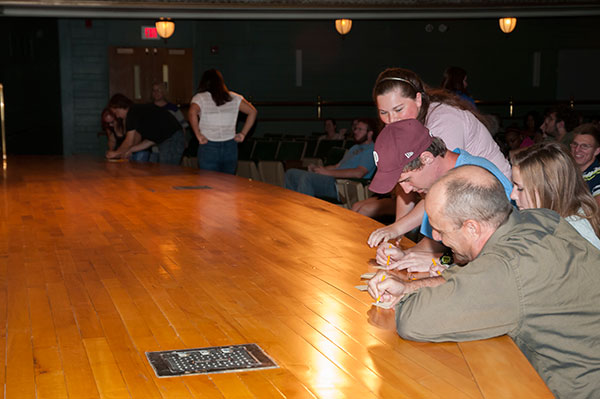 Attendees write down their song requests on the Klump Academic Center Auditorium stage ...