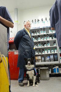 Faculty member Al Thomas with his service dog, Jesse, in the Collision Repair Lab at Penn College.