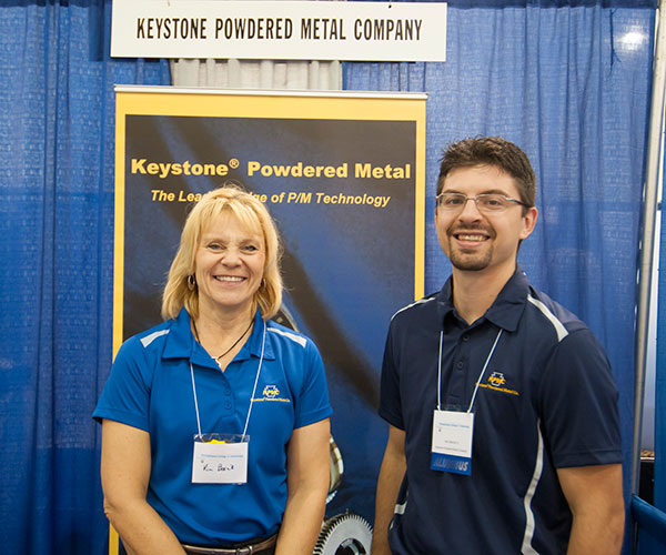 Joseph M. Harner, a May graduate in electronics and computer engineering technology, staffs the Keystone Powdered Metal Co. table with Kim Bosnik.