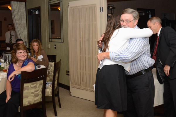 Michelle L. Wright hugs her father, William, after he introduced her; the honoree's mother, Lynn, smiles nearby.