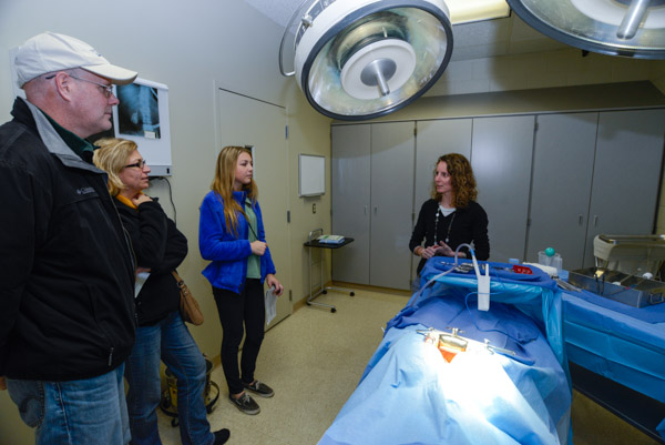 Among alumni returning to campus to offer Open House assistance is Jaime L. Binkley, '12, surgical technology, who discusses curriculum and career with visitors. 
