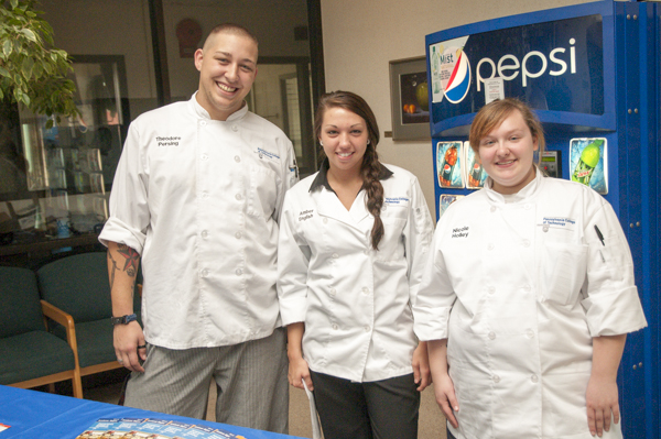 Students Theodore J. Persing, baking and pastry arts; Amber S. English, hospitality management; and Nicole Holley, culinary arts and systems, wait to greet visitors and escort them to baking, pastry and culinary arts facilities.